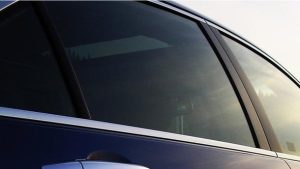Aracınıza Değer Katın Koyu renkli cam filmine sahip bir otomobil ve trafik denetimi.
